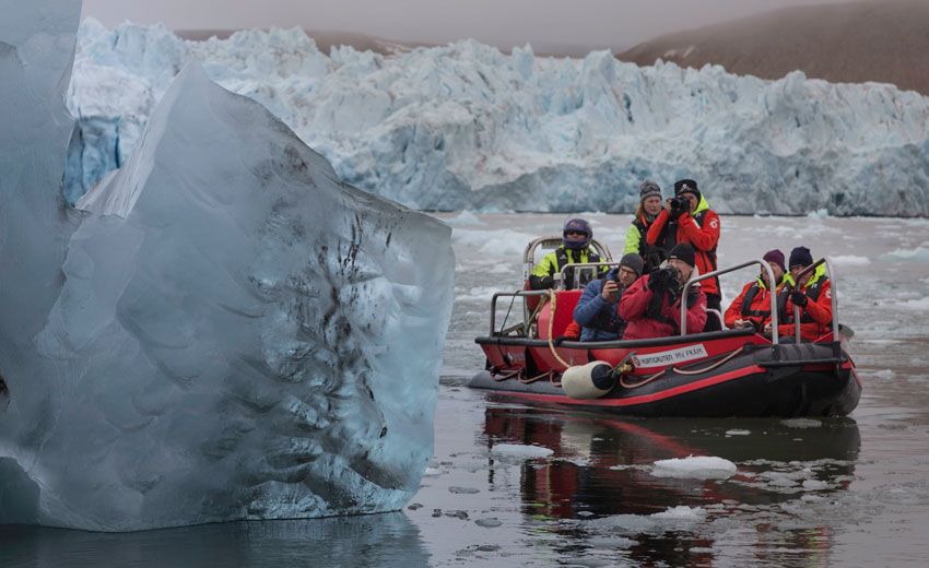 Tourists photographing an ice berg in Svalbard